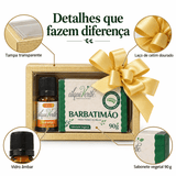 Detalhes da caixa dourada com tampa transparente, laço de cetim, frasco de vidro âmbar e sabonete de 90 g
